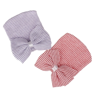 Detail of soft knitted baby hospital hats with large bow in purple and red stripes