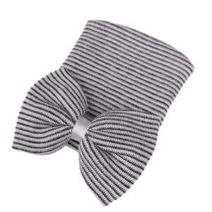 Detail shot of black and white striped knit baby hat featuring a large oversized bow