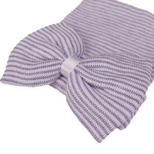 Close-up of knit baby hospital hat with purple white stripes and large bow detail