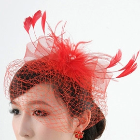 Detail of red feather fascinator hat with mesh netting and bead accents for parties