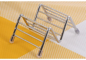 Detail of silver W-shaped stainless steel taco holder with non-slip rubber feet