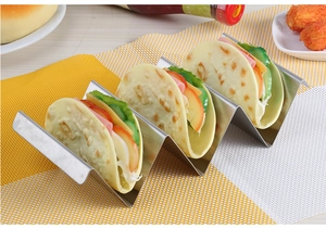 Stainless steel taco holder with wave design serving three tacos on a dining table mat