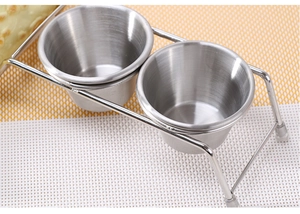 Detail of stainless steel taco holder with two dipping sauce cups and protective feet