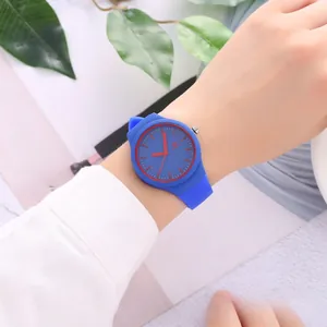 Close-up of minimalist blue silicone watch with striking red hands and markers on wrist