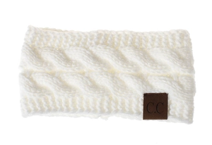 Detail of white cable-knit headband with C.C leather tag and warm textured yarn