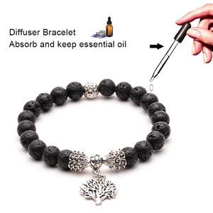 Lava stone diffuser bracelet with Tree of Life charm showing essential oil application