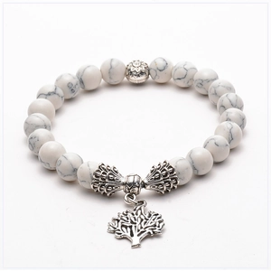 Detail of white marble beads and silver Tree of Life charm on a beaded yoga bracelet