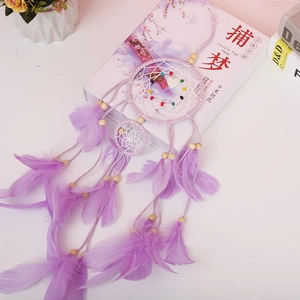Detail of purple dream catcher with feathers and heart pendant for bedroom decoration