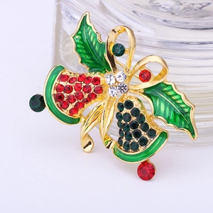 Macro view of a gold-plated Christmas bell brooch with red and green rhinestones