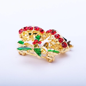 Detail of hollow bell Christmas brooch with red rhinestones and green holly enamel