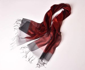 Detail of silk organza scarf with shimmering gold thread, tassels, and color gradient