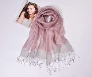 Detailed view of pink silk organza scarf with gold metallic fringe and grey sheer edges