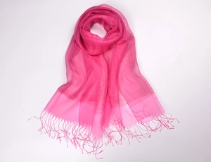 Close-up of vibrant rose red silk organza scarf with shimmering gold tassel details