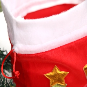 Detail of red velvet Christmas gift bag with golden star embroidery and plush white trim