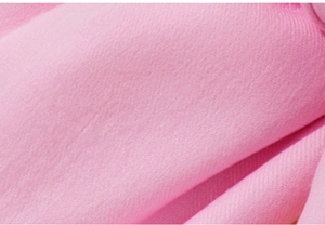 Macro shot of soft pink faux cashmere fabric showing detailed woven texture and fiber