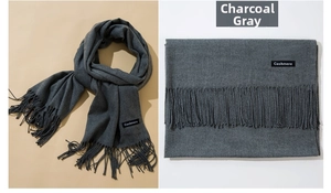 Detail of heather grey cashmere scarf showing soft texture with fringe and woven labels
