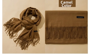 Close-up of soft camel cashmere scarf featuring elegant tassel fringe and brand label