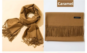 Close-up of caramel cashmere scarf with soft tassel edges and branded fabric label