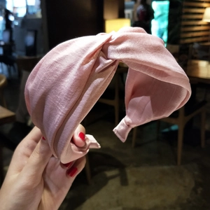 Detail shot of a soft pink twisted fabric headband with delicate silk texture