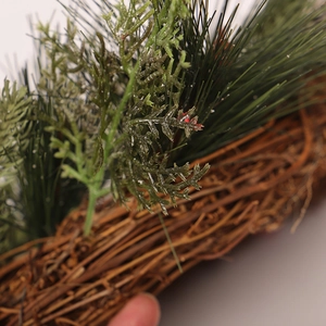 Ghirlanda natalizia con aghi di pino verdi e base in rattan per decorazioni festive