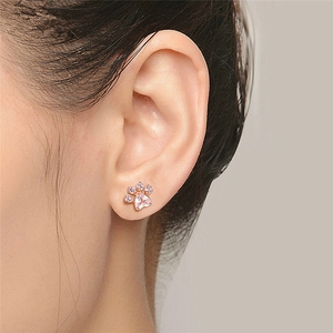 Rose gold cat paw earrings with pink crystal heart stones on model ear