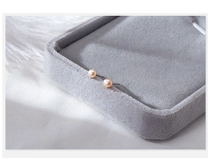 Macro shot of elegant natural freshwater pearl earrings on grey velvet jewelry display