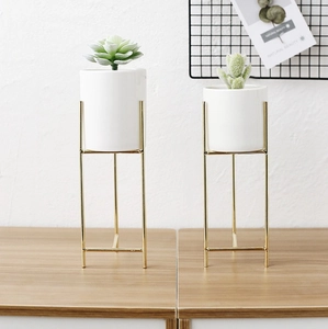 Dettagli di fioriere minimaliste in ceramica bianca con eleganti supporti in metallo oro