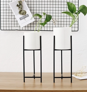 Dettagli di fioriere minimaliste in ceramica bianca con eleganti supporti in metallo nero