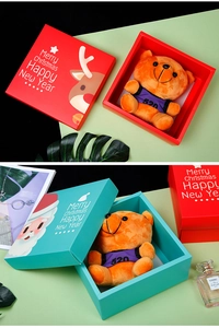 Detailed view of Christmas gift boxes with plush bear and festive cartoon patterns