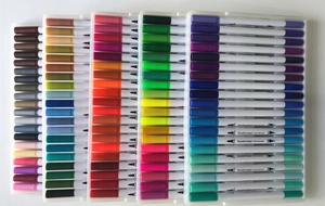 Flat lay of colorful dual tip markers showing brush and fine nibs for art sets