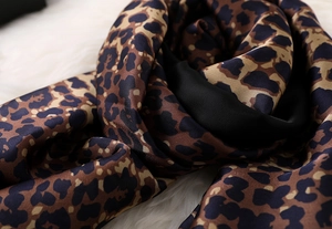 Macro shot of silk leopard scarf texture with smooth satin sheen on plush background