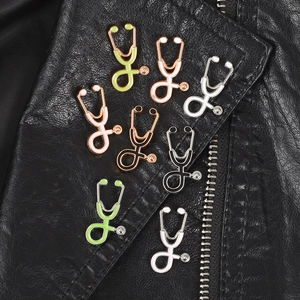 Set of colorful vintage stethoscope enamel brooches on black leather jacket lapel