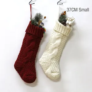 Classic knitted Christmas stockings in red and white with cable stitch pattern and pine decor