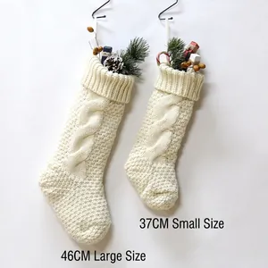 Cream knit Christmas stockings with cable patterns in 46cm and 37cm sizes with pine decor