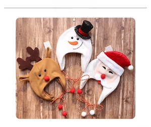 Detailed overhead view of festive plush Christmas hats for kids on a wooden background
