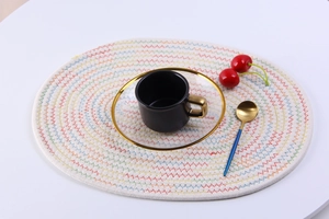 Detailed top view of an oval woven cotton placemat with colorful rainbow wave stitching