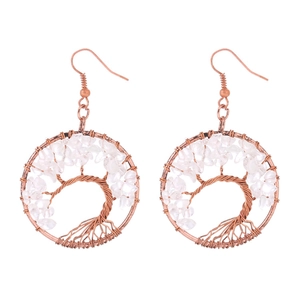 Macro view of handmade copper tree of life earrings with white crystal stone beads