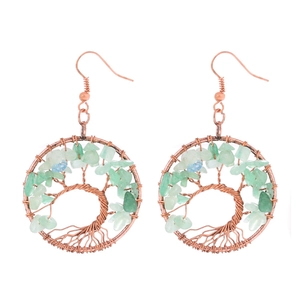 Detail of handmade bronze wire-wrapped tree of life earrings with green crystals