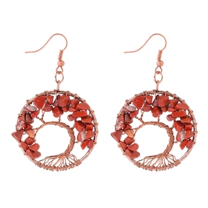 Detail of handcrafted copper wire tree of life earrings with natural red jasper stones