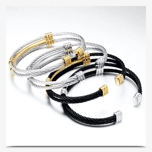 Detailed macro view of four stacked 10MM cable braid open bangles in gold, silver, and black