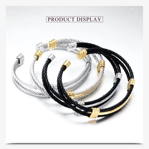 Detail view of woven stainless steel cable bracelets with gold and silver accents