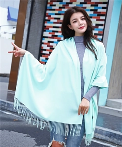 Detail shot of mint green cashmere shawl showing thick texture and elegant fringe tassels