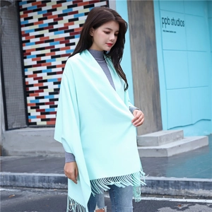 Detail of mint green cashmere-feel shawl showing soft texture and long fringe tassels