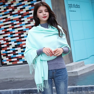 Pale mint green cashmere-style long scarf with tassels shown on a model in street style