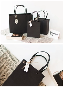 Three assorted sizes of matte black gift bags with sturdy rivets and elegant gift tags