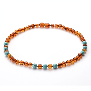 Macro detail of amber and turquoise beads with a secure screw clasp on the baby necklace
