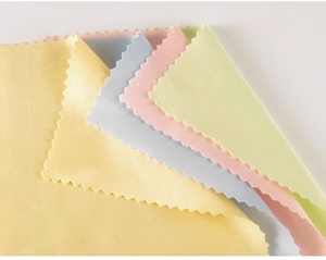 Close-up of four microfiber cleaning cloths in yellow, blue, pink, and green with serrated edges