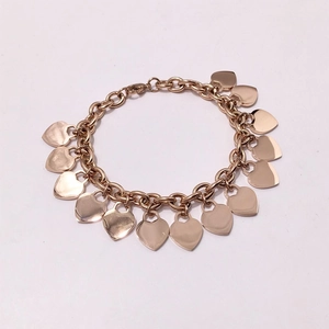 Detailed view of rose gold chunky link bracelet with thirteen polished heart charms