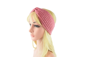 Detailed knit texture of pink twisted winter headband on a display model