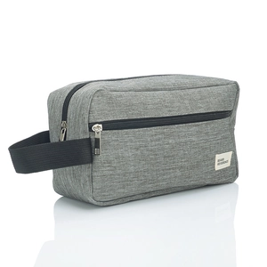 Macro detail of a grey travel toiletry bag with black side handle and zip closure